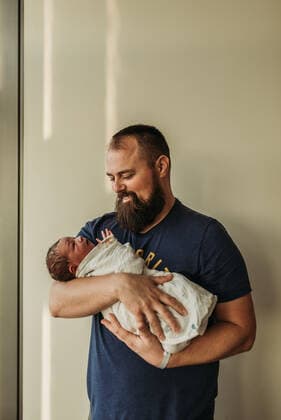 IMAGO Creative: Lokalhelden - Gesundheits- und Rettungskräfte Lifestyle portrait of dad holding newborn baby boy in birthing center San Diego, CA, United States CR_KESM210216-640841-01 ,model released, Symbolfoto