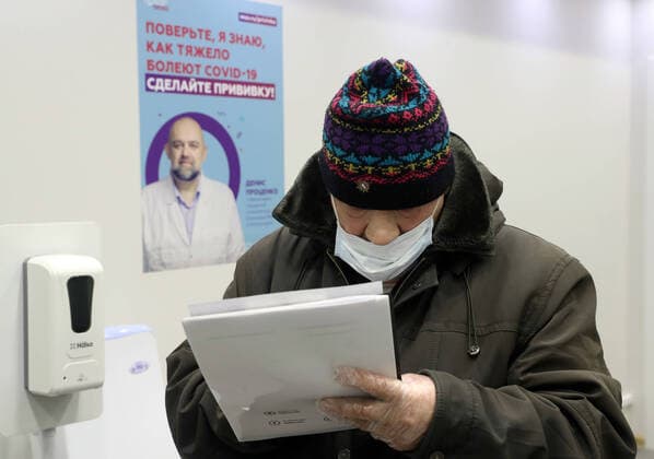 MOSCOW, RUSSIA - FEBRUARY 17, 2021: A man fills in his form to receive an injection of the Gam-COVID-Vac (marketed as Sputnik V) vaccine against COVID-19 in a vaccination room at the Evropeisky Europe shopping centre. The vaccination team works free of charge, no prior appointment required. Stanislav Krasilnikov TASS  TS0F70AB
