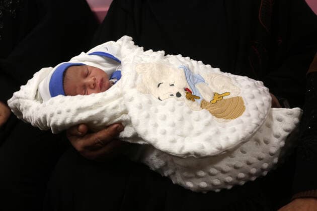 February 18, 2021, khan Younis, Gaza Strip, Palestinian Territory: Relatives of the Palestinian prisoner Muhammad al-Qudra carry the newborn, at Nasser Medical Complex in khan Younis in the southern of Gaza strip on February 18, 2021. Eman al-Qudra gave birth to her newborn in a successful smuggling of sperm to lead to a pregnancy. Since 2004, Palestinian security prisoners, who are denied conjugal visitations by their wives, have tried to smuggle their sperm out of Israeli prisons, so that their wives can be inseminated in fertility clinics in the West Bank and Ghazza, and bear them children khan Younis Palestinian Territory - ZUMAap3_ 20210218_zaf_ap3_184 Copyright: xAshrafxAmrax