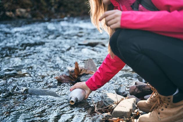 IMAGO Creative: Klimawandel - Nachhaltiges Reisen Hiker woman taking water in river after hiking. girl enjoying outdoors summer trekking vacation. Salamanca, CL, Spain CR_OSPE210218-648930-01 ,model released, Symbolfoto