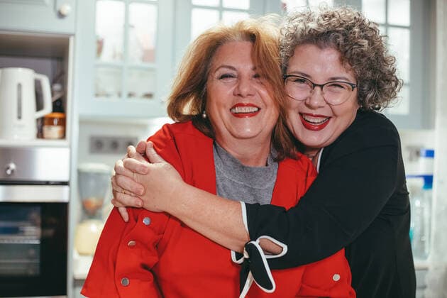IMAGO Creative: Internationaler Frauenmonat, Gesundheit, Frauen in der Menopause Glad middle aged lesbian woman embracing smiling female beloved in house looking at camera Copyright: xDanixNavarrox Model Released