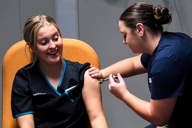 ACT COVID19 VACCINE ROLLOUT, Registered nurse Maddison Williams (left) receives the first jab of the Biotech Pfizer COVID-19 vaccine at the COVID-19 surge centre in Canberra, Monday, February 22, 2021. Australia will begin its roll out of the Pfizer coronavirus vaccine on Monday, the country s most complicated logistical exercise to date. ( NO ARCHIVING, EDITORIAL USE ONLY, NO USE IN BOOKS WITHOUT CONSENT CANBERRA ACT AUSTRALIA  Copyright: xLUKASxCOCHx 20210222001522299030