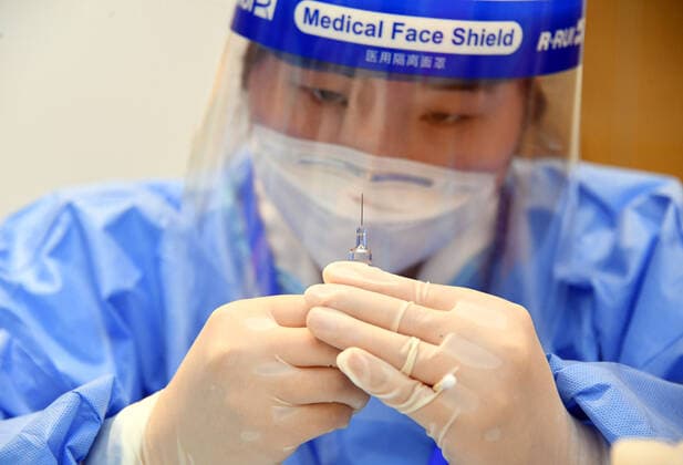 (210222) -- BEIJING, Feb. 22, 2021 -- A medical worker prepares a vaccine at a temporary COVID-19 vaccination site at a company in the ZPark Phase 2 in Haidian District of Beijing, capital of China, Feb. 22, 2021. It is expected to take two days to complete the vaccination of more than 3,800 employees of the enterprise. ) CHINA-BEIJING-HAIDIAN-VACCINATION (CN) RenxChao 