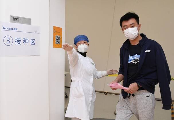 (210222) -- BEIJING, Feb. 22, 2021 -- A medical worker (L) guides a man for vaccination at a temporary COVID-19 vaccination site at a company in the ZPark Phase 2 in Haidian District of Beijing, capital of China, Feb. 22, 2021. It is expected to take two days to complete the vaccination of more than 3,800 employees of the enterprise. ) CHINA-BEIJING-HAIDIAN-VACCINATION (CN) RenxChao 