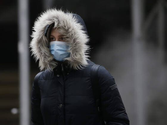 A pedestrian walks wearing a face mask to protect from and to prevent the spread of the coronavirus on Wall Street in New York City on Monday February 22, 2021. COVID-19 deaths have now surpassed the 500,000 mark in the United States.  NYP20210222109 JohnxAngelillo
