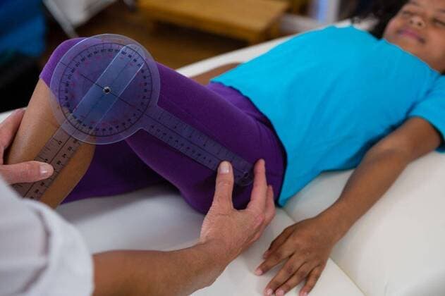 Physiotherapist examining girl patients leg with goniometer Physiotherapist examining girl patients leg with goniometer in the clinic, model released, , property released, Cape Town, South Africa, 2017-04-22T23:00:00.000Z, 1052669.jpg, physio, physiotherapy, physiotherapist, practitioner, orthopedic, osteopath, physical therapy, physical therapist, therapy, doctor, clinic, hospital, specialist, health service, healthcare, bodycare, healthcare and medicine, expertise, profession, professional, recovery, care, treatment, injury, patient, holding, examining, checking, leg, joint, assistance, assisting, measurement, measuring, goniometer, medical ruler, instrument of measurement, equipment, accuracy, childhood, innocence, cute 50s, Mature Adul
