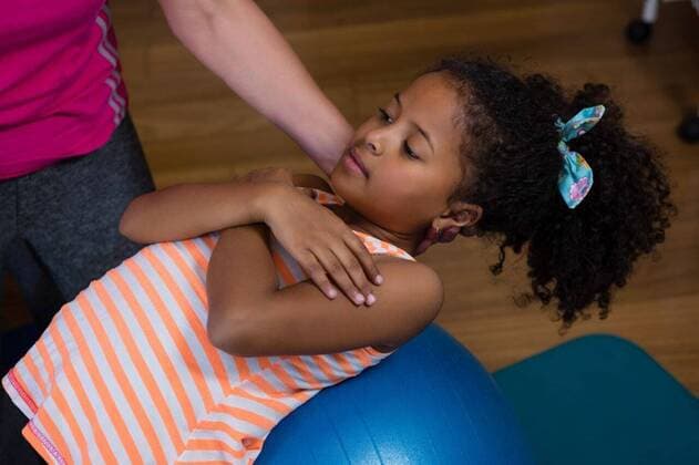 Female physiotherapist helping girl patient in performing exercise on fitness ball Female physiotherapist helping girl patient in performing exercise on fitness ball in clinic, model released, , property released, Cape Town, South Africa, 2017-04-22T23:00:00.000Z, 1052737.jpg, physio, physiotherapy, physiotherapist, practitioner, orthopedic, physical therapy, physical therapist, therapy, clinic, hospital, health service, healthcare, bodycare, healthcare and medicine, sportswear, training, routine, healthy lifestyle, wellness, wellbeing, active, activity, fitness, healthy, physical, determination, exercise, exercising, workout, working out, patient, helping, assistance, stretching, exercise ball, fitness ball, balance ball, equipment, gym e