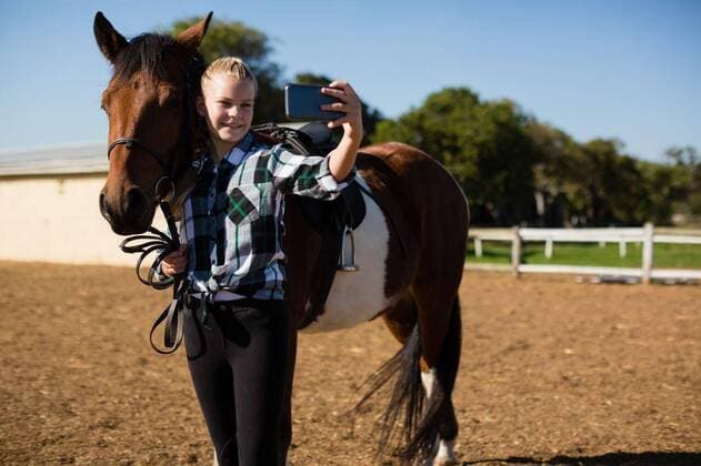 IMAGO Creative, Kinder auf dem Reiterhof Girl taking a selfie with horse Girl taking a selfie with horse at the ranch, model released, , property released, Cape Town, South Africa, 2017-05-02T23:00:00.000Z, 1053072.jpg, rider, countryside, farm, ranch, summer, summertime, casual clothing, smartphone, mobile phone, cellphone, phone, selfie, photo, photographing, memories, wireless technology, communication, global communication, connection, selfie stick, pony, thoroughbred, stallion, horse, domestic animal, vacation, holiday, lifestyle, hobby, leisure, childhood, innocence, learning, happy Child, Girl, Female, Caucasian, 12-13 Years, Girls, Caucasian Ethnicity Outdoors,Day