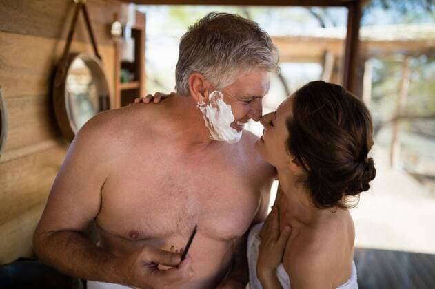 Smiling couple looking face to face while shaving in cottage Smiling couple looking face to face while shaving in cottage during safari vacation, model released, , property released, Cape Town, South Africa, 12.05.2017, 1064683.jpg, sunny, summer, couple, relationship, looking, smiling, cheerful, happy, face to face, tourist, cottage, lodge, hotel, resort, shirtless, towel, standing, mirror, razor, holding, blade, apply, shaving cream, shave, beard, foam, clean, fresh, freshness, ready, morning, routine, hygiene, skincare, journey, travel, trip, vacation, leisure, lifestyle, recreation, tourism, weekend activity, together, love, bonding, affection, closeness, romantic, romance 50s, Mature Adult, Man, Male, Caucasian, 30s, Mid Adult, Woman,