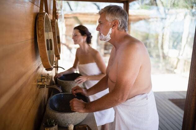 Couple looking at mirror in cottage Couple looking at mirror in cottage during safari vacation, model released, , property released, Cape Town, South Africa, 12.05.2017, 1064687.jpg, sunny, summer, couple, relationship, looking, tourist, cottage, lodge, hotel, resort, shirtless, towel, standing, mirror, basin, faucet, shaving brush, apply, shaving cream, shave, beard, foam, clean, fresh, freshness, ready, morning, routine, hygiene, skincare, journey, travel, trip, vacation, leisure, lifestyle, recreation, tourism, weekend activity, together, love, bonding, affection 50s, Mature Adult, Man, Male, Caucasian, 30s, Mid Adult, Woman, Female, 55-59 Years, Mature Men, Caucasian Ethnicity, 35-39 Years, Mid Adult Women