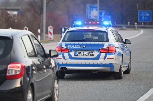 Grenzkontrollen an der oesterreichisch deutschen Grenze ,Grenzuebergang Kiefersfelden Grenzpolizisten kontrollieren Autofahrer bei der Einreise von Tirol Oesterreich nach Bayern Deutschland. Ein Polizeiauto,Streifenwagen leitet abgewiesene Einreisende bis zur naechsten Autobahnausfahrt. Einreise verweigert,abgewiesen,