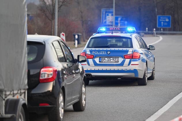 Grenzkontrollen an der oesterreichisch deutschen Grenze ,Grenzuebergang Kiefersfelden Grenzpolizisten kontrollieren Autofahrer bei der Einreise von Tirol Oesterreich nach Bayern Deutschland. Ein Polizeiauto,Streifenwagen leitet abgewiesene Einreisende bis zur naechsten Autobahnausfahrt. Einreise verweigert,abgewiesen,
