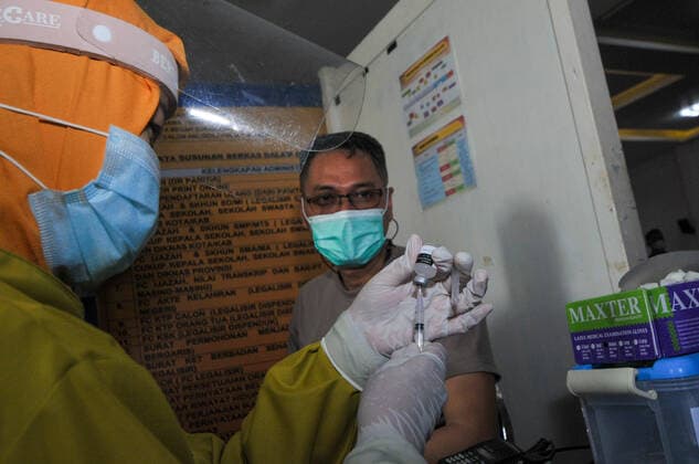 Mass vaccination for police personnel in Indonesia Police personnel get vaccinated for the COVID-19 coronavirus at the police headquarters in Surabaya, East Java, Indonesia on February 23, 2021. as part the country s efforts against the COVID-19 coronavirus pandemic. (Photo by Julian Romadhon INA Photo Agency) 