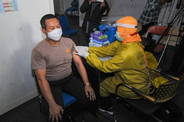 Mass vaccination for police personnel in Indonesia Police personnel get vaccinated for the COVID-19 coronavirus at the police headquarters in Surabaya, East Java, Indonesia on February 23, 2021. as part the country s efforts against the COVID-19 coronavirus pandemic. (Photo by Julian Romadhon INA Photo Agency) 