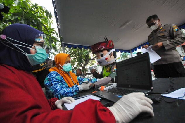 Mass vaccination for police personnel in Indonesia Police personnel get vaccinated for the COVID-19 coronavirus at the police headquarters in Surabaya, East Java, Indonesia on February 23, 2021. as part the country s efforts against the COVID-19 coronavirus pandemic. (Photo by Julian Romadhon INA Photo Agency) 