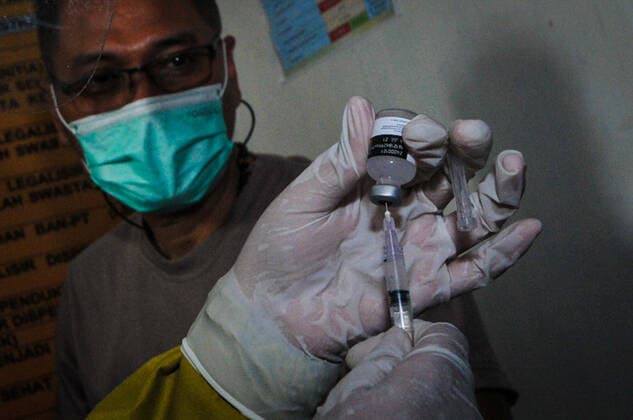 Mass vaccination for police personnel in Indonesia Police personnel get vaccinated for the COVID-19 coronavirus at the police headquarters in Surabaya, East Java, Indonesia on February 23, 2021. as part the country s efforts against the COVID-19 coronavirus pandemic. (Photo by Julian Romadhon INA Photo Agency) 