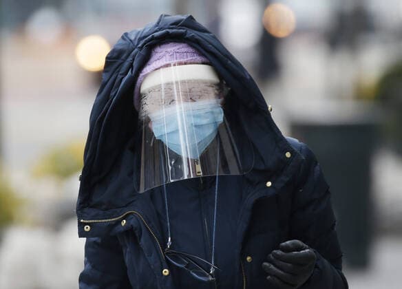 A pedestrian walks wearing a face mask and fogged up face shield to protect from and to prevent the spread of the coronavirus in New York City on Tuesday, February 23, 2021. COVID-19 deaths have now surpassed the 500,000 mark in the United States.  NYP20210223104 JohnxAngelillo