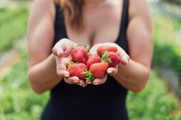 Female farmer holding fresh ripe strawberries in hands model released Symbolfoto JRVF00188