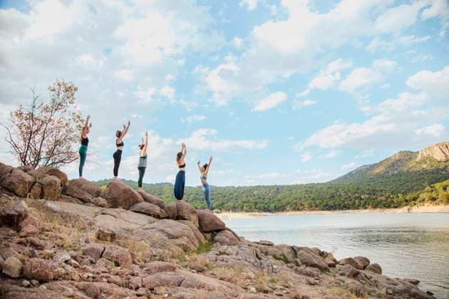 Young women practicing yoga with instructor on rock against sky model released Symbolfoto property released MRRF00792
