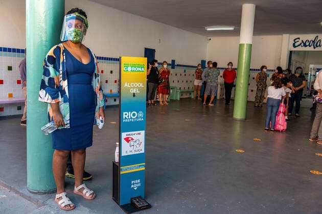 COVID-19 Back To School RIO DE JANEIRO, BRAZIL, FEB 24: COVID-19 BACK TO SCHOOL- Public elementary schools reopen after almost a year of pandemic recess. Teacher waits for students to check their temperature and sanitize hands at school entrance on February 24, 2021. ( Photo by Chico Ferreira Penta Press ) Rio de Janeiro Brazil 6203_232800 Copyright: xChicoxFerreira PentaxPressx