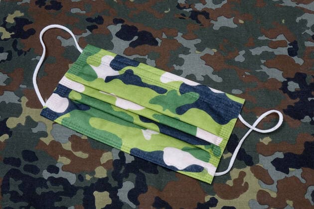 Mundschutzmaske und Bundeswehr Mundschutzmaske und Bundeswehr, 24.02.2021, Borkwalde, Brandenburg, Eine Mundschutzmaske liegt auf einem Tarnstoff.
