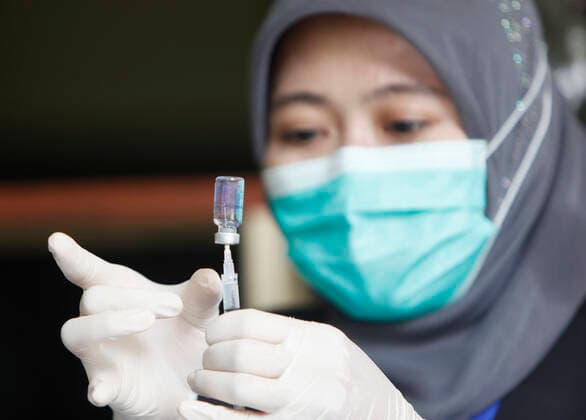 COVID-19 vaccination Second phase to In Bogor, Indonesia A medical worker prepares to inject a dose of COVID-19 vaccine during a mass vaccination in Bogor on February 25, 2021. Indonesia has started the second phase of a national COVID-19 vaccination campaign, one million people in Indonesia have been inject a vaccine. 