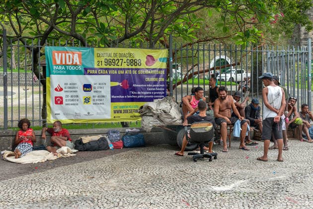 COVID-19 Food Assistance in Brazil RIO DE JANEIRO, BRAZIL, FEB 25: COVID-19 FOOD ASSISTANCE - Homeless people and people in precarious situations wait free meal distributed by NGO volunteers during the COVID-19 pandemic at downtown Rio , in the background, a poster asks for donations , on Feb. 25, 2021. Rio de Janeiro Brazil 6209_232884 Copyright: xChicoxFerreira PentaxPressx