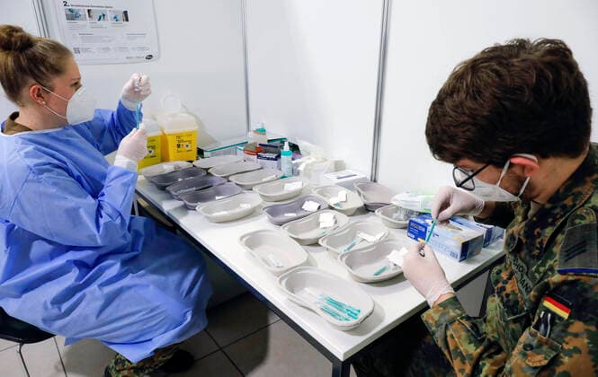 Impfzentrum Schoenefeld Schoenefeld, DEU, 26.02.2021 - Spritzen werden von Soldaten der Bundeswehr mit dem Covid19 Biontech Pfizer Impfstoff Comirnaty befuellt, im Impfzentrums am Terminal 5 des BER Flughafens. Schoenefeld Brandenburg Deutschland