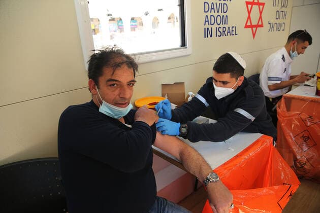 (210226) -- JERUSALEM, Feb. 26, 2021 -- A man receives the COVID-19 vaccine in a mobile clinic in Jerusalem, on Feb. 26, 2021. (Photo by Xinhua) MIDEAST-JERUSALEM-COVID-19-VACCINATION MuammarxAwad 