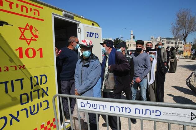 (210226) -- JERUSALEM, Feb. 26, 2021 -- People line up to receive the COVID-19 vaccine outside a mobile clinic in Jerusalem, on Feb. 26, 2021. (Photo by Xinhua) MIDEAST-JERUSALEM-COVID-19-VACCINATION MuammarxAwad 