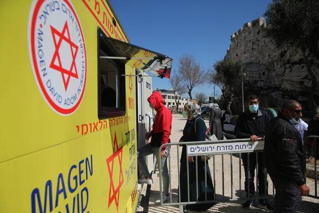 (210226) -- JERUSALEM, Feb. 26, 2021 -- People line up to receive the COVID-19 vaccine outside a mobile clinic in Jerusalem, on Feb. 26, 2021. (Photo by Xinhua) MIDEAST-JERUSALEM-COVID-19-VACCINATION MuammarxAwad 