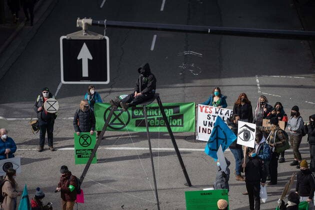 February 27, 2021, Vancouver, BC, Canada: A person sits on a tripod platform high above the street as protesters occupy an intersection during an Extinction Rebellion demonstration to call for government action to address the climate and ecological crisis, in Vancouver, on Saturday, February 27, 2021. Vancouver Canada  - ZUMAc35_ 20210227_zaf_c35_082 Copyright: xDarrylxDyckx