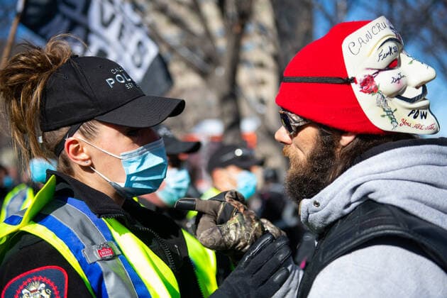 News Bilder des Tages February 27, 2021, Calgary, Alberta, Canada: Anti-mask protestor confronts a Calgary Police Officer during the Freedom March protest in Calgary, AB on 27 Feb, 2021. Led by pastors Artur and David Pawlowski, the march carried tiki torches said to signify the light of the lord but also reminiscent of the Charlottesville Unite the Right rally in 2017. Calgary Canada - ZUMAj113 20210227_zip_j113_002 Copyright: xGavinxJohnx