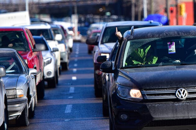 February 27, 2021, Calgary, Alberta, Canada: A motorist gestures at the anti-mask protest Freedom March in Calgary, AB on 27 Feb, 2021. The march was led by people who carried tiki torches said to signify the light of the lord but also reminiscent of the Charlottesville Unite the Right rally in 2017. Calgary Canada - ZUMAj113 20210227_zip_j113_006 Copyright: xGavinxJohnx