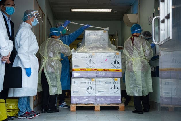 (210228) -- MACAO, Feb. 28, 2021 -- Staff members disinfect the packages of vaccines in Macao, south China, Feb. 27, 2021. The first batch of 100,000 doses of mRNA vaccines made in Germany arrived in Macao on Saturday. ) CHINA-MACAO-VACCINES-ARRIVAL (CN) CheongxKamxKa 
