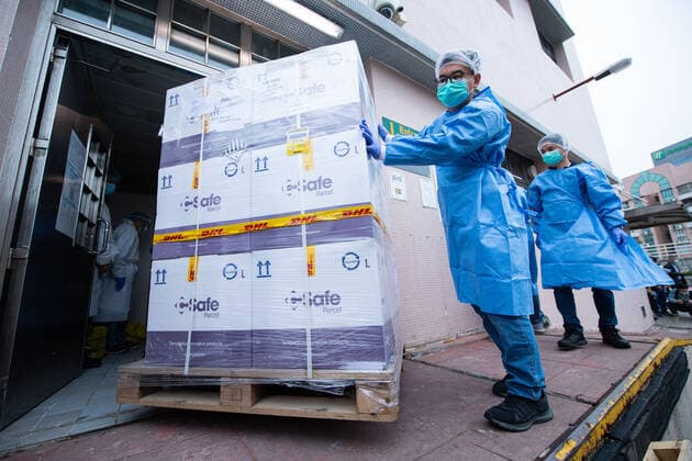 (210228) -- MACAO, Feb. 28, 2021 -- Staff members transfer vaccines in Macao, south China, Feb. 27, 2021. The first batch of 100,000 doses of mRNA vaccines made in Germany arrived in Macao on Saturday. ) CHINA-MACAO-VACCINES-ARRIVAL (CN) CheongxKamxKa 