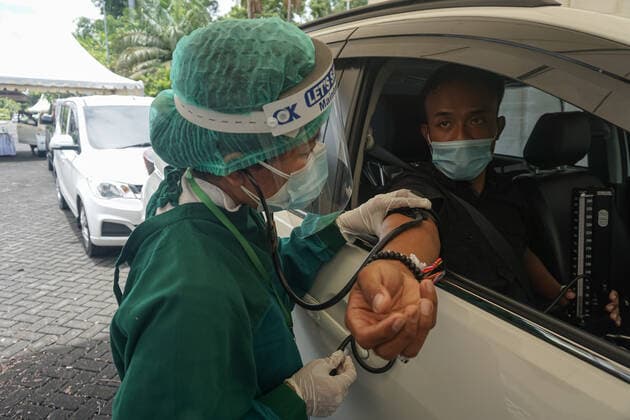 February 28, 2021, Badung, Bali, Indonesia: A healthworker serving health-screening before the drive-thru vaccination process. Bali to held the second stage of Covid-19 mass vaccination towards tourism workers and online-taxi drivers at Bali Nusa Dua Convention Center (BNDCC), in order to accelerate tourism industry recovery. About 5000 doses of vaccines are targeted to be completed within 1 week. Badung Indonesia - ZUMAb245 20210228_zip_b245_001 Copyright: xDickyxBisinglasix