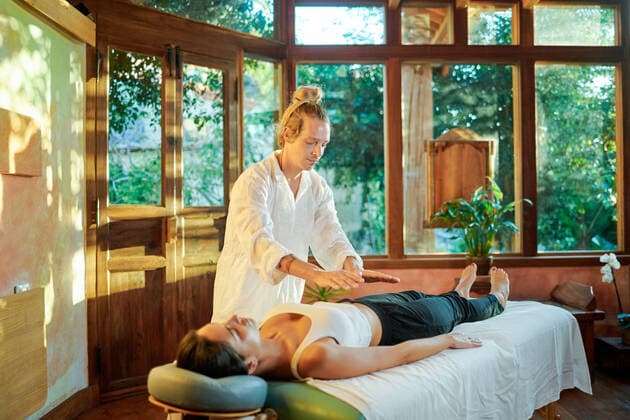 IMAGO Creative, Lifestyle, Esoterik gef?hrlicher Glaube Healer practicing palm healing technique for female client lying on couch during spiritual practice for filling with harmony and energy, Model released, Property released Copyright: xGabrielxTrujillox MR