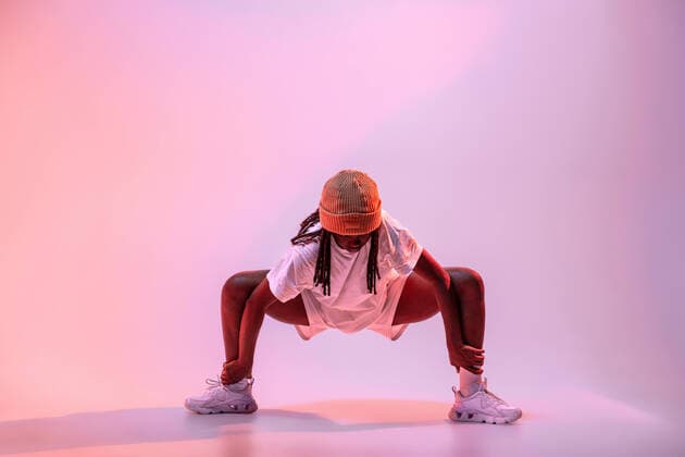 IMAGO Creative: Internationaler Frauenmonat, M?dchen im Sport Full body of concentrated African American teen dancing with hands outstretched in studio with bright neon light Copyright: xManuelxRuizx Model Released