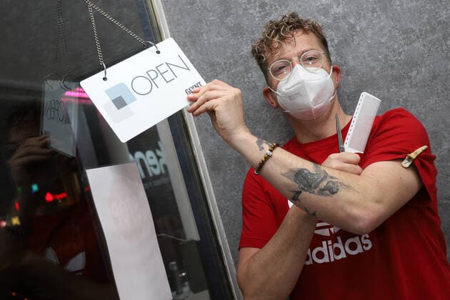 Corona-Pandemie, Friseure duerfen nach Wochen endlich wieder arbeiten, das Haarstudio Verlockend in Eiserfeld empfaengt seit 06:00 Uhr wieder seine Kunden, Inhaber Ulli Boenisch (Bönisch) mit Kamm, Schere und Schild OPEN am Eingang freut sich auf seine Kunden Friseure in der Corona-Pandemie am 01.03.2021 in Siegen Deutschland.
