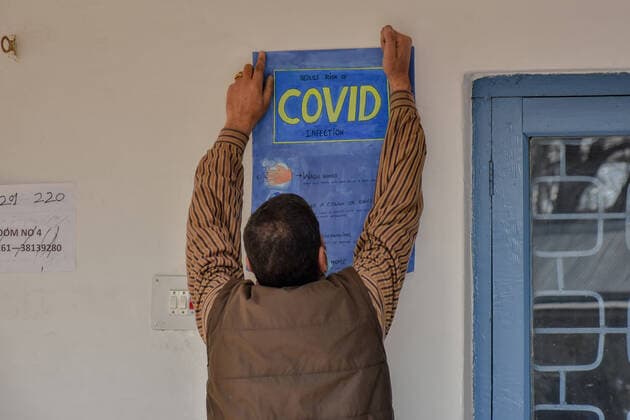 March 1, 2021, Srinagar, India: A staff member pastes a poster of Covid-19 precautions inside the school premises as the schools reopened after one year of break due to the coronavirus pandemic in Srinagar..The schools in Kashmir have reopened for students of classes 9 to 12 after being shut down for nearly one year due to the coronavirus pandemic. Even before the Covid-19 forced their closure, the educational institutes remained closed for nearly a year on of the security and communication clampdown following the abrogation of Article 370 on 5 August 2019. Meanwhile, Jammu and Kashmir recorded 97 new Covid-19 cases taking the infection tally to 1,26,383, officials said. Srinagar India - ZUMAs197 20210301_zaa_s197_060 Copyright: xSaqibxMajeedx