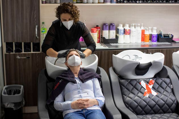 01.03.2021 , DU Duisburg , Friseure dürfen ab dem 01.03.2021 wieder öffnen , Sadiye Kisin vom Friseursalon Haarscharf in Duisburg - Buchholz hat den ersten Termin in ihrem Salon am Marktplatz um 00:01 Uhr versteigert. SPD-Landtagspolitikerin Sarah Philipp hat mit ihrem Gebot von 500 Euro gewonnen , Kisin verdoppelt den Betrag , insgesamt gehen 1000 Euro an die Kindernothilfe in Duisburg. Friseurin Sadiye Kisin wäscht Sarah Philipp die Haare.