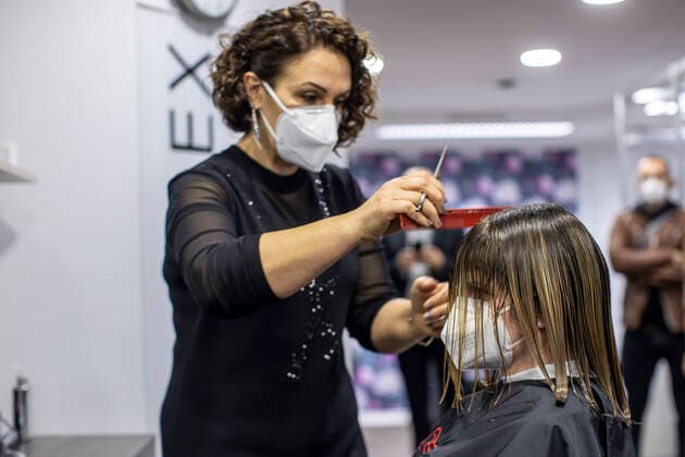 01.03.2021 , DU Duisburg , Friseure dürfen ab dem 01.03.2021 wieder öffnen , Sadiye Kisin vom Friseursalon Haarscharf in Duisburg - Buchholz hat den ersten Termin in ihrem Salon am Marktplatz um 00:01 Uhr versteigert. SPD-Landtagspolitikerin Sarah Philipp hat mit ihrem Gebot von 500 Euro gewonnen , Kisin verdoppelt den Betrag , insgesamt gehen 1000 Euro an die Kindernothilfe in Duisburg. Friseurin Sadiye Kisin schneidet Sarah Philipp die Haare.
