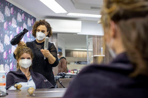 01.03.2021 , DU Duisburg , Friseure dürfen ab dem 01.03.2021 wieder öffnen , Sadiye Kisin vom Friseursalon Haarscharf in Duisburg - Buchholz hat den ersten Termin in ihrem Salon am Marktplatz um 00:01 Uhr versteigert. SPD-Landtagspolitikerin Sarah Philipp hat mit ihrem Gebot von 500 Euro gewonnen , Kisin verdoppelt den Betrag , insgesamt gehen 1000 Euro an die Kindernothilfe in Duisburg. Friseurin Sadiye Kisin föhnt Sarah Philipp die Haare.