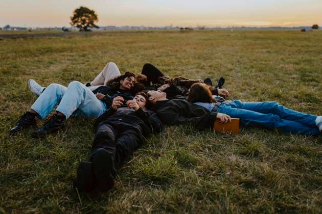 Young male and female friends lying on grass in park Germany, Berlin, model released Copyright: xMaskotx , MA84315