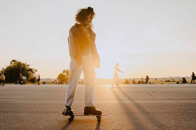 Young woman standing on skateboard in park Germany, Berlin, model released Copyright: xMaskotx , MA84342