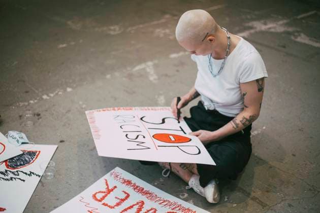 IMAGO Creative: Bildung, Schreiben IMAGO Creative: Resilienz IMAGO Creative: 2021 Trends Female activist preparing stop racism signboard Sweden, Stockholm, model released, property released Copyright: xMaskotx , MA84458