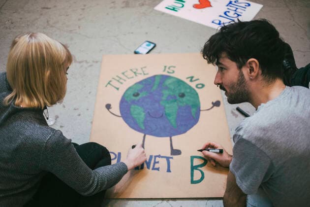 Young male and female protestor preparing poster for environmental issues Sweden, Stockholm, model released, property released Copyright: xMaskotx , MA84464