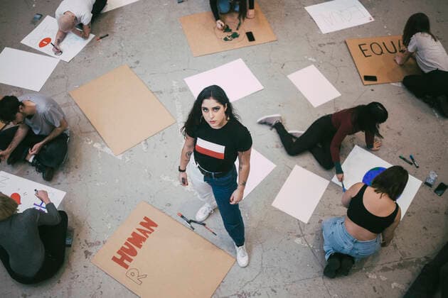 High angle portrait of woman standing while male and female activist preparing signboards in building Sweden, Stockholm, model released, property released Copyright: xMaskotx , MA84513