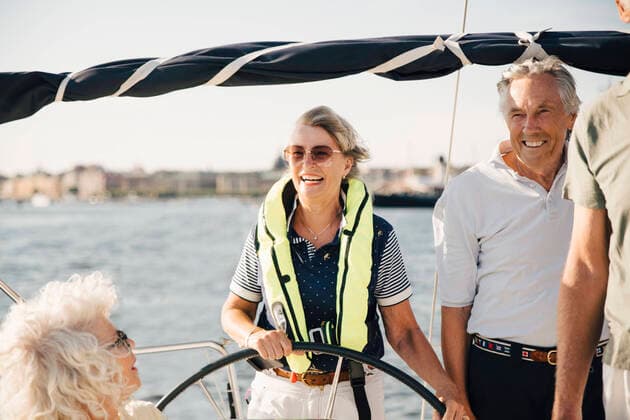 Cheerful senior woman sailing boat with happy friends on sunny day Sweden, Stockholm, model released, property released Copyright: xMaskotx , MA84593